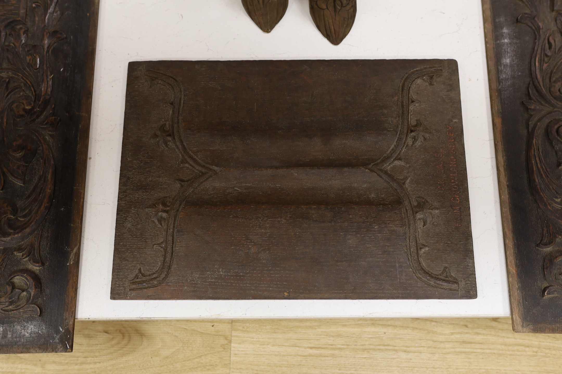 Three carved oak panels and a pair of brackets, one linenfold oak panel carved ‘from Crowland Abbey’, 46 cm X 33 cm